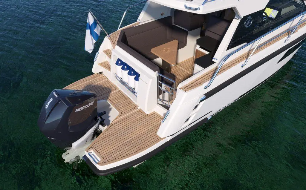 A motorboat with a Mercury engine, wooden deck, and Finnish flag, anchored above clear water in a scenic outdoor setting.